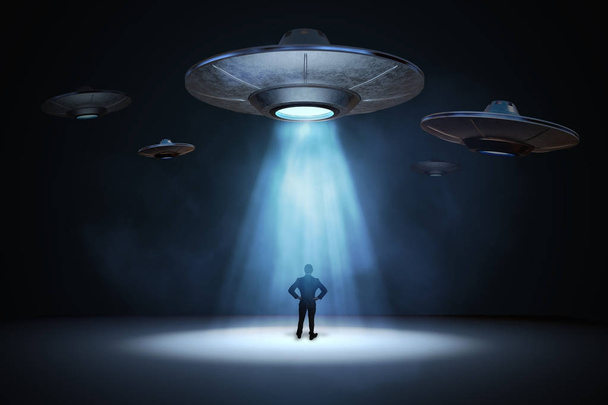 Концепция вторжения пришельцев. Человек, стоящий под лучом света от флаина
 - Фото, изображение