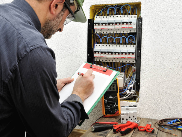 Electrician technician at work with protective helmet on a resid - Photo, Image