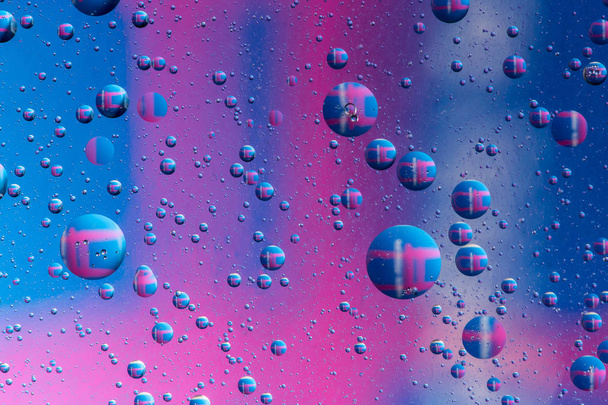 красочные пузырьки масла на водной поверхности абстрактного фона с голубым
 - Фото, изображение