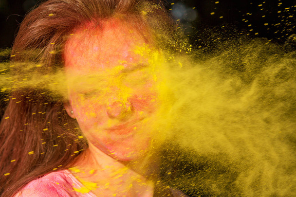 Closeup portrait of amazing brunette girl with Holi paint blowin - Valokuva, kuva