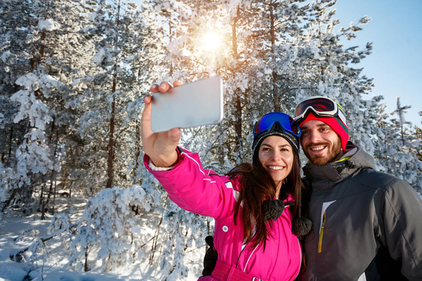 couple having fun on the snow and making selfie - Photo, Image