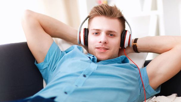 Man listening music with headphones at home - Фото, изображение