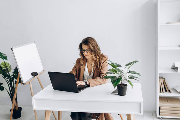 Красива розумна бізнес-леді працює на ноутбуці на своєму робочому місці в офісі
 - Фото, зображення