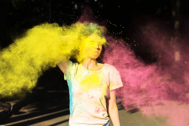 Lovely girl posing with yellow and pink Holi powder exploding ne - Fotó, kép