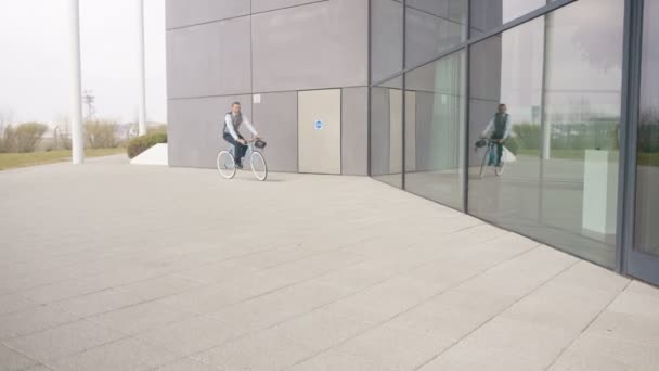 4K Businessman arriving for work on a bicycle on a sunny day - Felvétel, videó