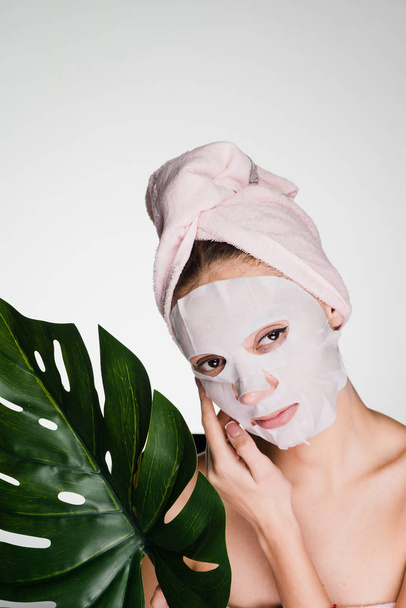 woman with a towel on her head apply a cleansing mask on her face - Fotoğraf, Görsel