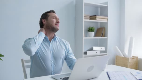 Tired man massaging neck while working on laptop - Felvétel, videó
