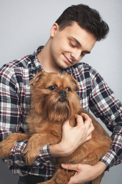 Closeup πορτρέτο όμορφος νεαρός hipster άνθρωπος, φιλώντας τον καλό φίλο κόκκινο σκύλο απομονωμένες ανοιχτόχρωμο φόντο. Θετικά ανθρώπινα συναισθήματα, έκφραση του προσώπου, τα συναισθήματα - Φωτογραφία, εικόνα