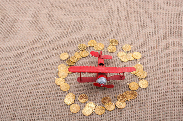 Fake gold coins around the retro model airplane - Foto, Bild