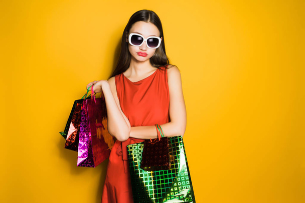 woman on a yellow background is standing with purchases - Photo, image