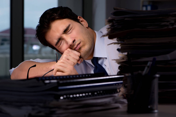 Молодий бізнесмен працює понаднормово пізно в офісі
 - Фото, зображення