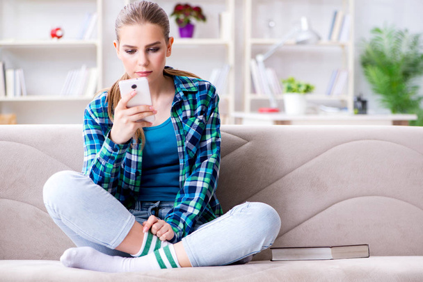 Female student sitting on the sofa with mobile - Photo, image