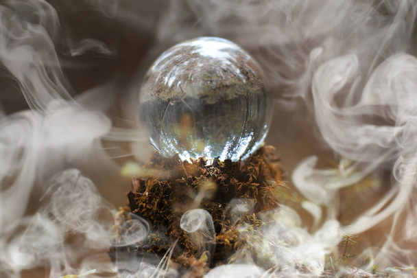 Μια κρυστάλλινη σφαίρα στον καπνό. Ένα μαγικό αξεσουάρ μέσα στο δάσος σε - Φωτογραφία, εικόνα
