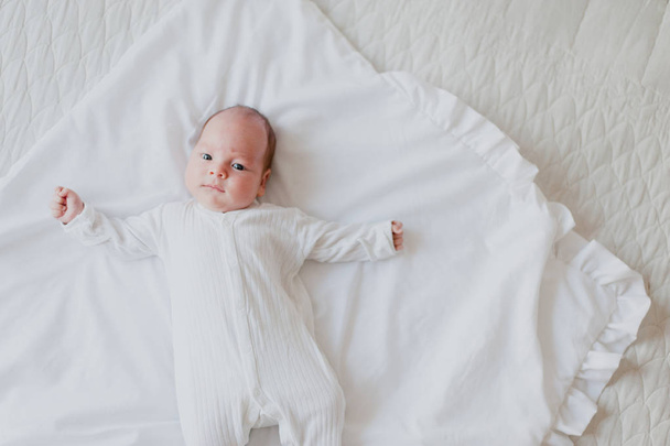 Newborn lying on his back on the bed  - Foto, Bild