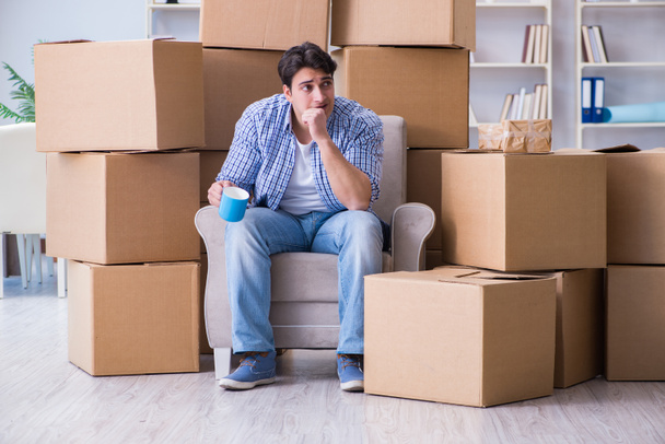 Jeune homme emménageant dans une nouvelle maison avec des boîtes - Photo, image