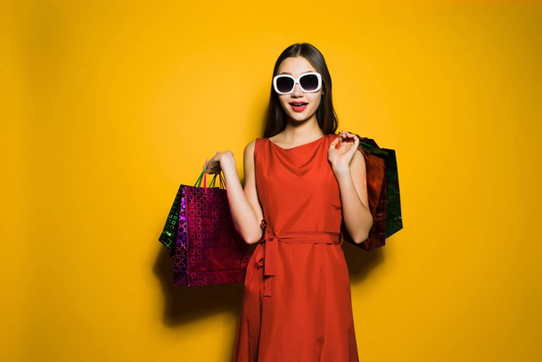 woman on yellow in sunny background comes home with shopping - Foto, Bild
