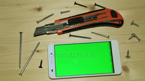 A smartphone with a green screen for your content and construction tools. - Footage, Video