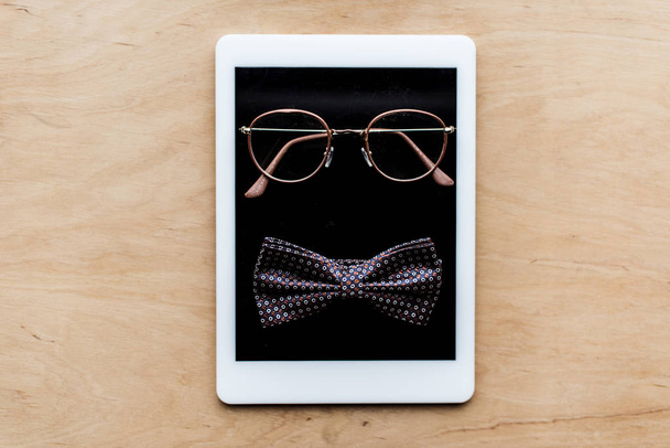 top view of glasses and tie bow on tablet - Photo, Image
