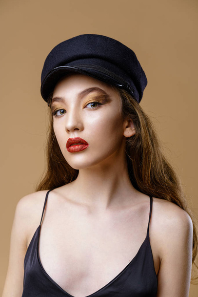 Portrait of gorgeous young fashion model in hat posing on studio background  - Fotó, kép