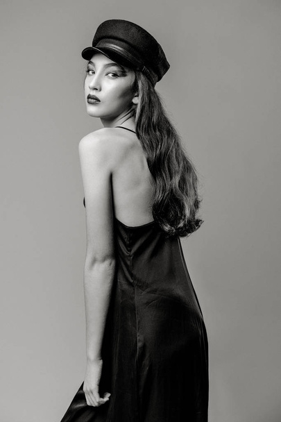 Black and white photo of gorgeous young fashion model posing on studio background  - Фото, изображение