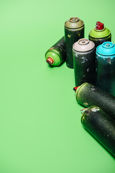 close up view of arranged cans with aerosol paint isolated on green - Foto, immagini