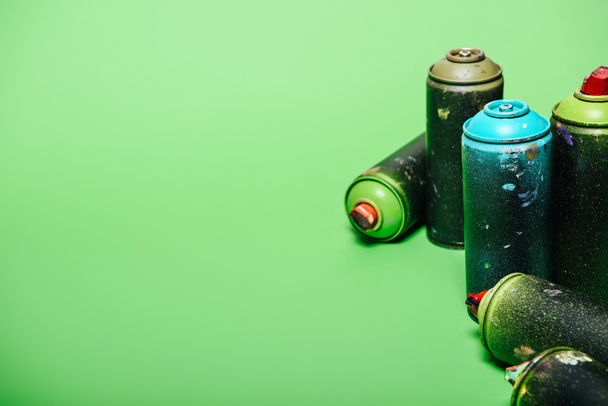 close up view of arranged cans with aerosol paint isolated on green - Foto, immagini