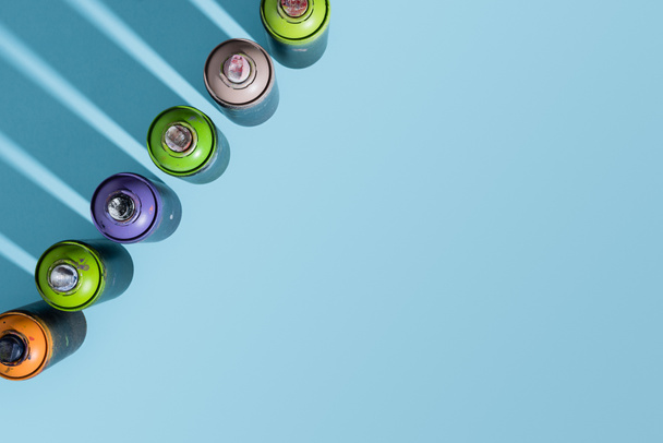 top view of arranged cans with aerosol paint isolated on blue - Foto, immagini