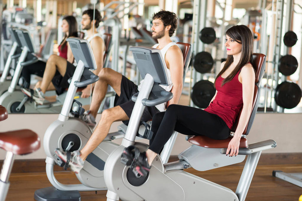 Group of people working out on a stationary bike - Photo, Image