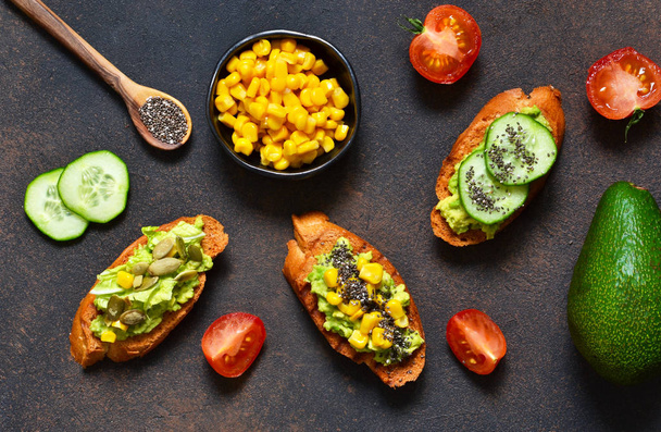 Toasts with avocado, corn tomato and cucumber. - Фото, зображення