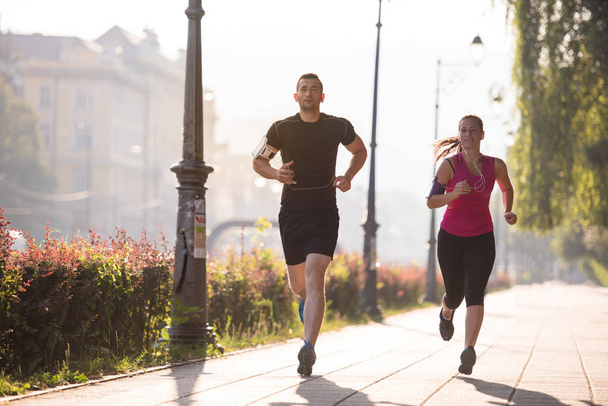 urban sports, healthy young couple jogging  in the city at sunny morning - Valokuva, kuva