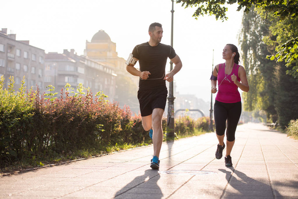 urban sports, healthy young couple jogging  in the city at sunny morning - Foto, afbeelding