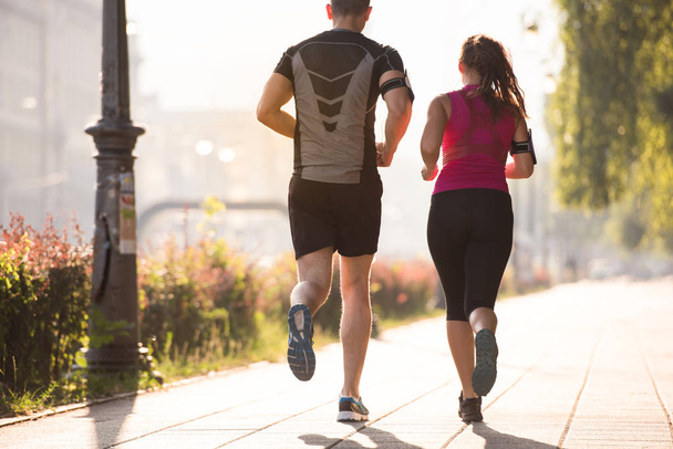 городской спорт, здоровая молодая пара бег трусцой в городе в солнечное утро
 - Фото, изображение