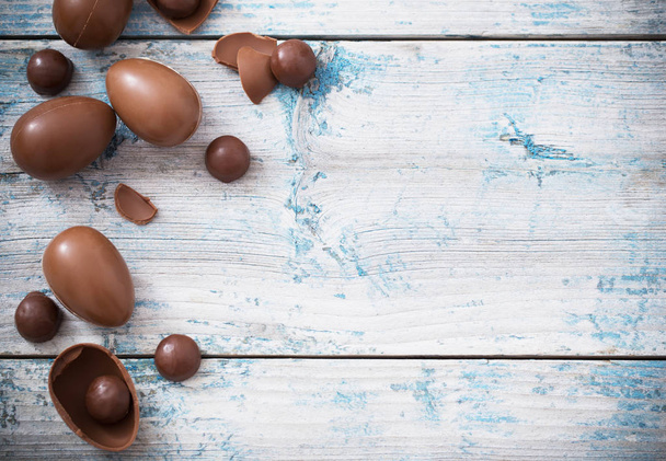 Chocolate eggs on old wooden background - Фото, изображение
