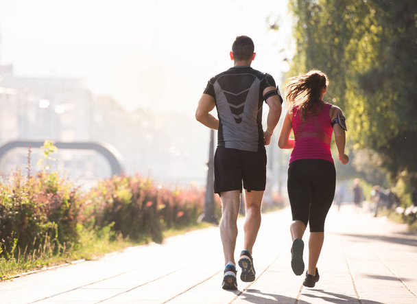 urban sports, healthy young couple jogging  in the city at sunny morning - Foto, imagen