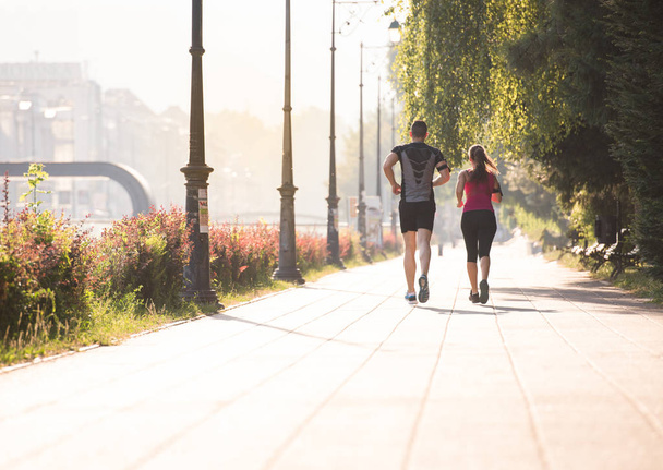 urban sports, healthy young couple jogging  in the city at sunny morning - Fotó, kép