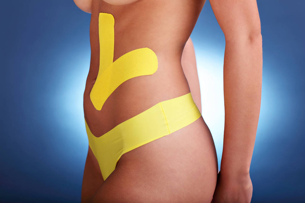 Picture showing special physio tape put on injured abdomen over white background - Valokuva, kuva