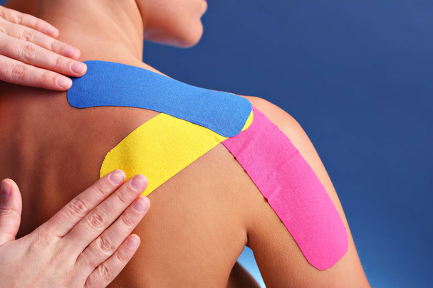 Picture showing special physio tape put on injured arm over white background - Фото, изображение