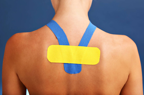 Bild mit speziellem Physioklebeband auf verletztem Rücken vor weißem Hintergrund - Foto, Bild
