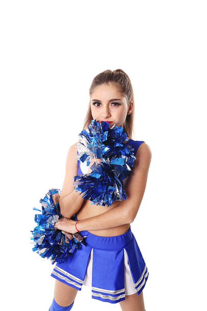 Jonge cheerleader in blauw en wit pak met pompoms op witte achtergrond. - Foto, afbeelding