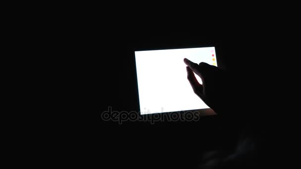 Finger draws on the tablet a symbol of peace and love, hippie sign, in the dark, close-up, 4k. - Záběry, video