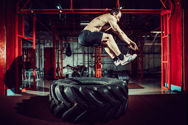 workout man jump in air on tire - Zdjęcie, obraz