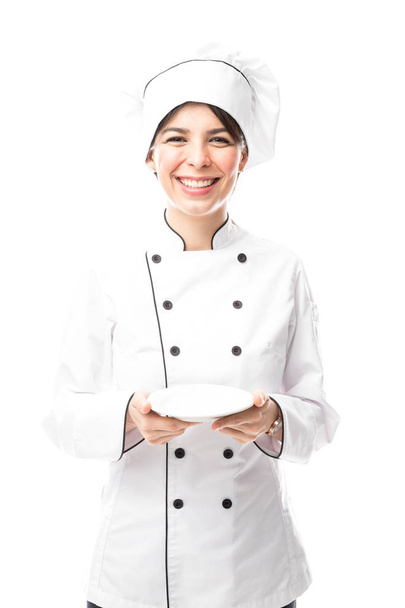 joven cocinera sosteniendo plato
  - Foto, Imagen
