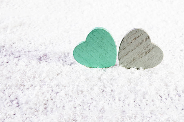 the Two wooden green and grey heart on white artificial snow - Фото, зображення