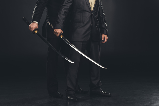 cropped shot of yakuza members with katana swords isolated on black - Photo, Image