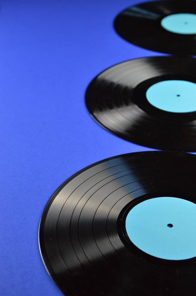 tři staré černé vinylových desek s prázdnou azurová popisky na modrém pozadí - Fotografie, Obrázek