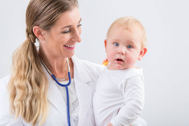 Pediatrik bakım uzmanı holding sevimli ve sağlıklı bebek kız portresi  - Fotoğraf, Görsel