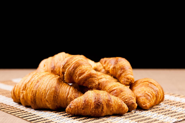 Freshly baked croissants lying on a table - Photo, Image