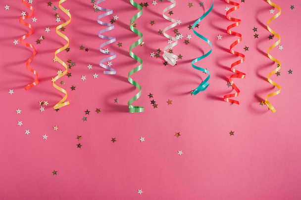 Fita de festa colorida serpenteia no fundo brilhante rosa. Festa ou conceito de aniversário
.  - Foto, Imagem