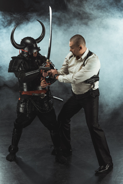 armored samurai fighting with man who holding gun - Foto, Imagen