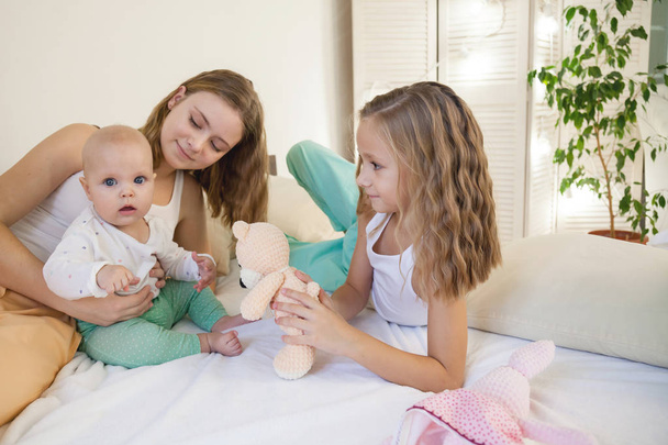 three sisters baby girl children in the morning on the bed in the bedroom - Фото, зображення